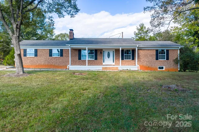 a front view of a house with a yard and trees
