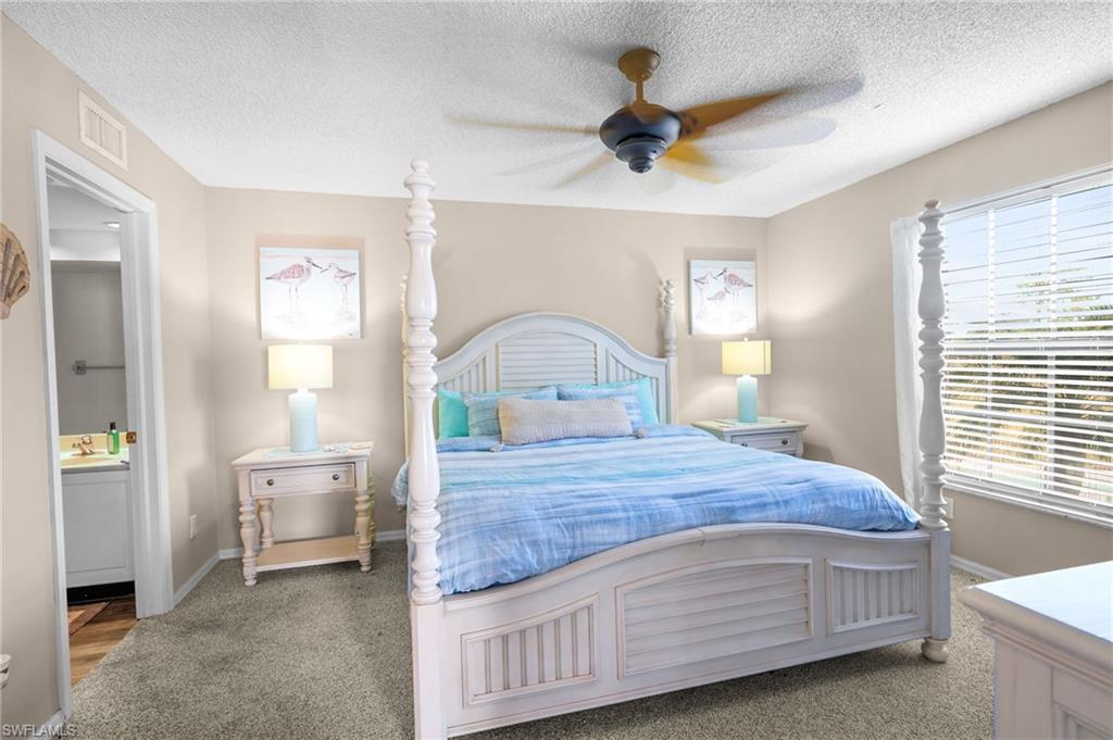 601 Augusta Boulevard, Unit 10 Naples, FL 34113 - Photo 11 of 27 Bedroom featuring carpet flooring, a textured ceiling, a ceiling fan, and ensuite bathroom