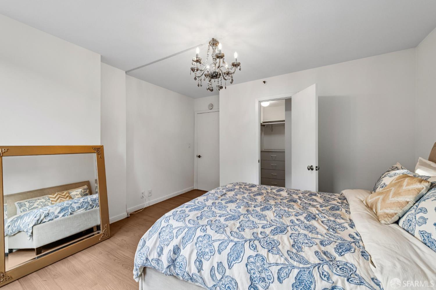 900 Bush Street, Unit 309 San Francisco, CA 94109 - Photo 13 of 25 a bedroom with a large bed and a chandelier