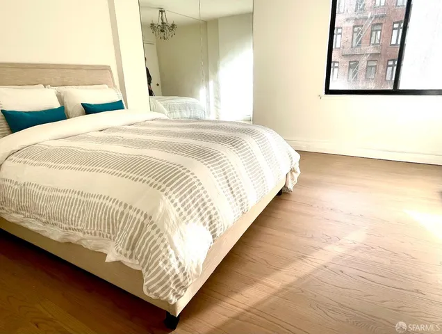 a large bed sitting in a bedroom next to a window