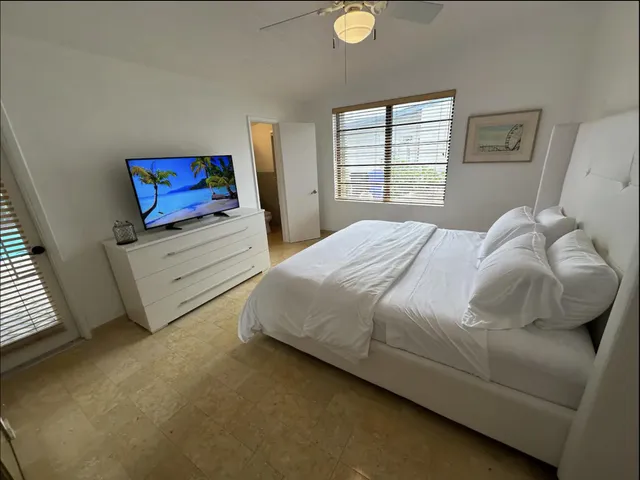 a bedroom with a bed and a lamp on dresser