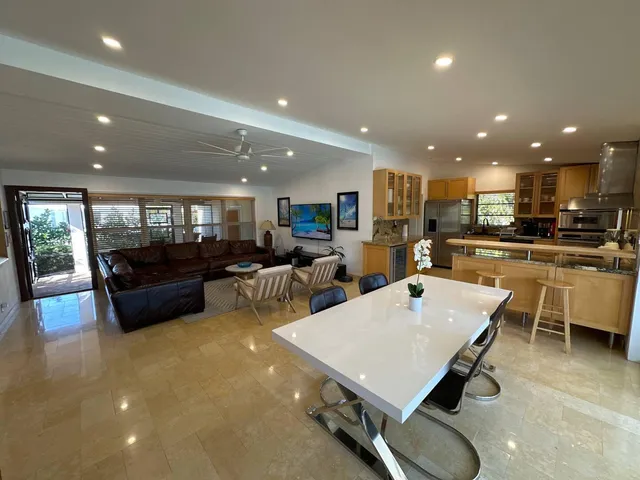 a living room with stainless steel appliances furniture and kitchen view