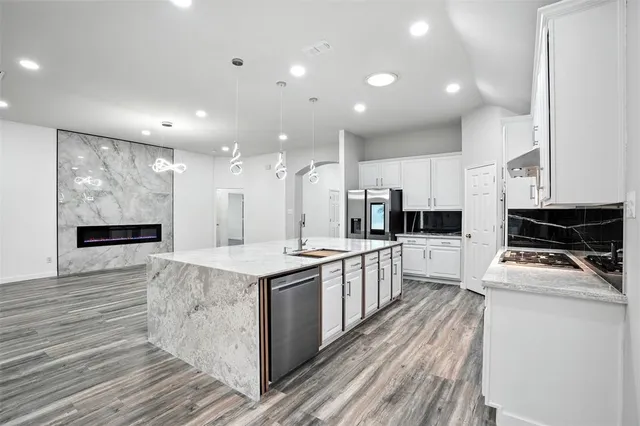 a kitchen with stainless steel appliances kitchen island granite countertop a stove and a sink