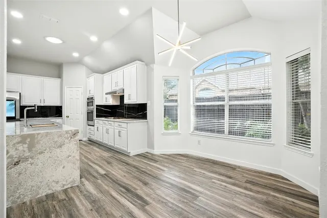 a kitchen with granite countertop a stove a sink and a refrigerator