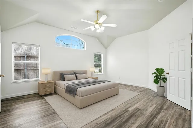 a bedroom with a large bed chandelier and a window