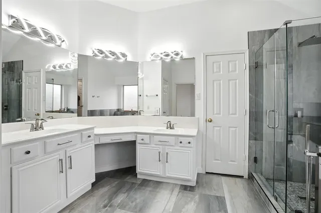 a large bathroom with a double vanity sink a mirror and shower