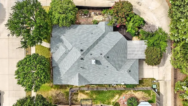 an aerial view of a house with a yard and large trees