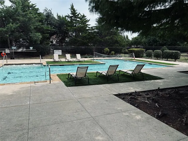 a view of a swimming pool with a garden and trees