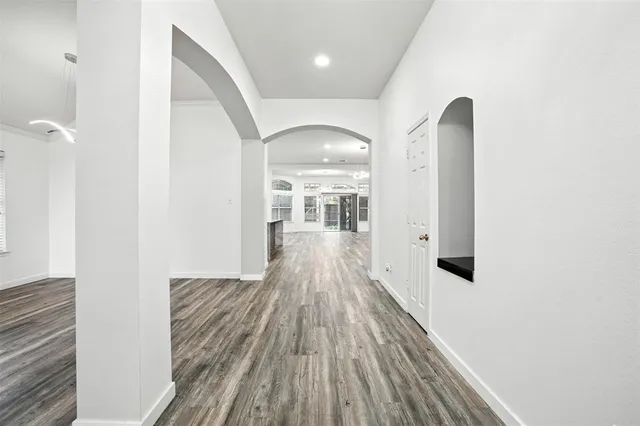 a view of a hallway with wooden floor and staircase