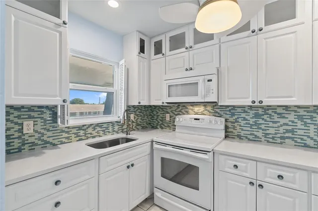 a kitchen with cabinets and white appliances