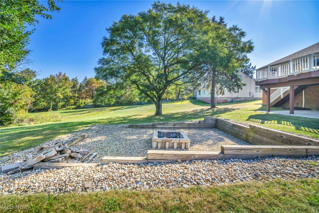 4523 Oakes Road Brecksville, OH 44141 - Photo 49 of 50 View of green lawn featuring stairs, a patio, a fire pit, and a wooden deck