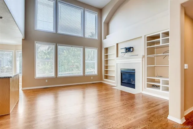 a view of a livingroom with wooden floor and a fireplace