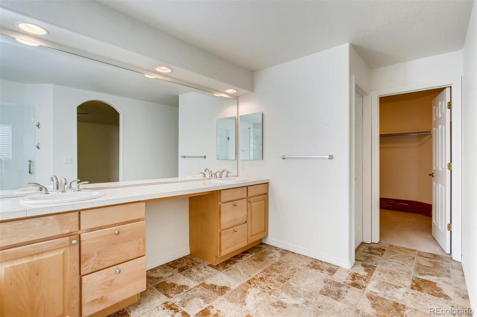 9535 East Aspen Hill Place Lone Tree, CO 80124 - Photo 19 of 28 a spacious bathroom with a double vanity sink and a mirror