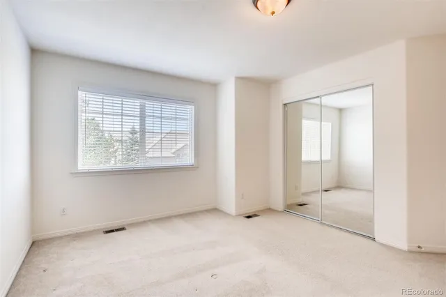an empty room with windows and closet