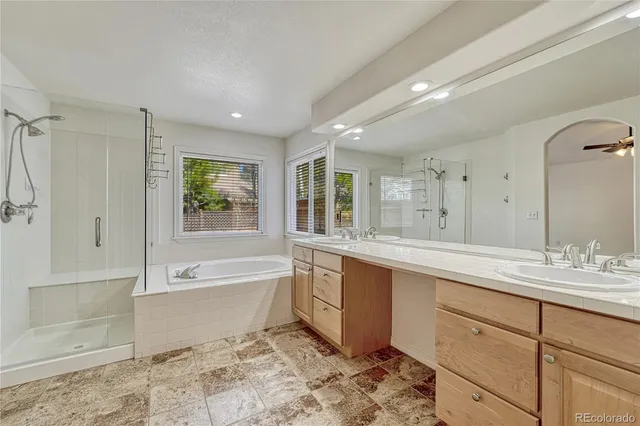 a spacious bathroom with a tub sink shower and mirror