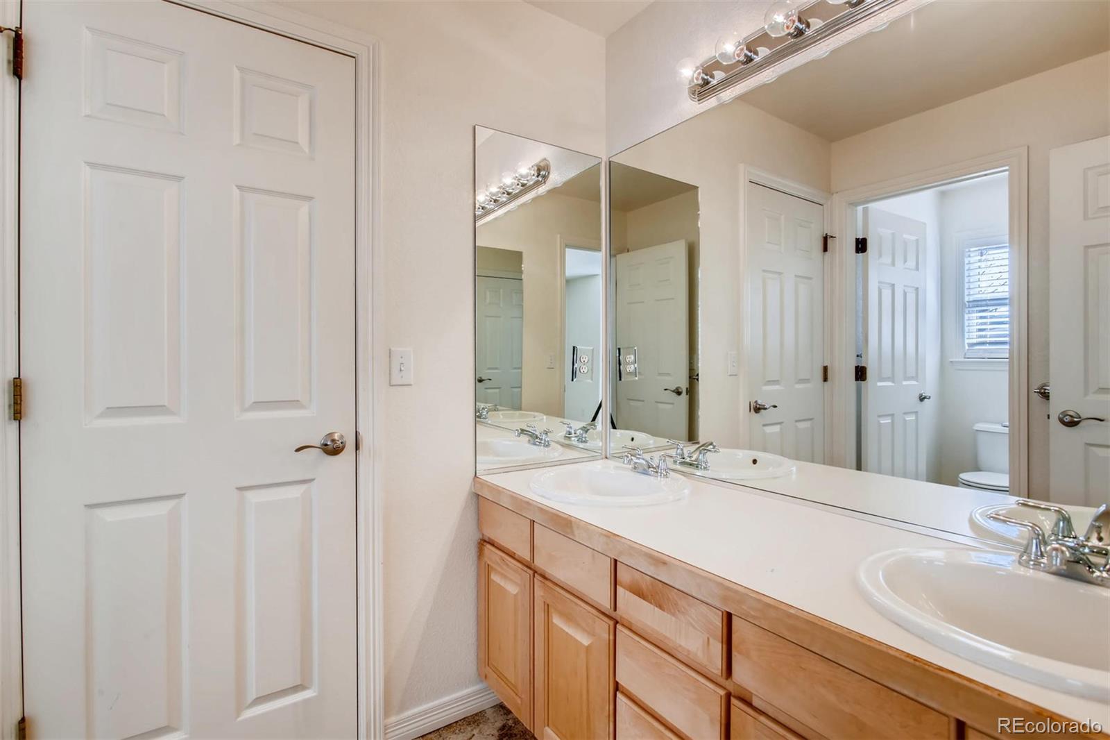 9535 East Aspen Hill Place Lone Tree, CO 80124 - Photo 25 of 28 a bathroom with a double vanity sink and a mirror