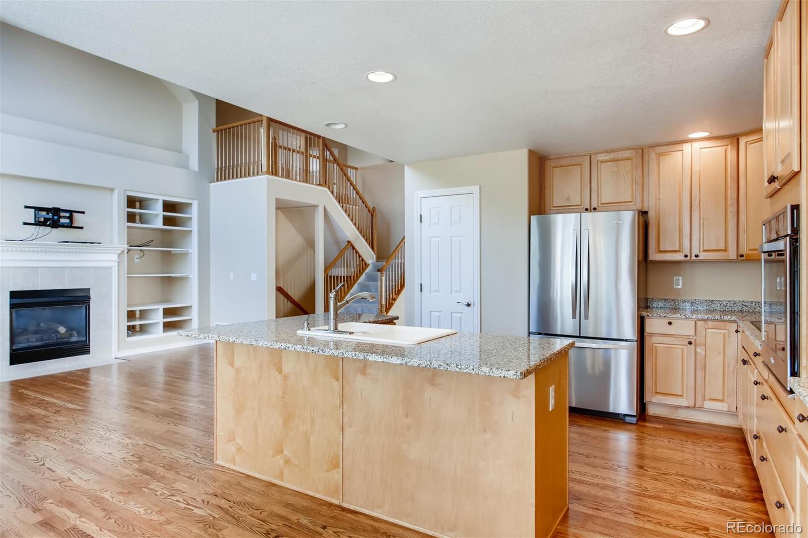 9535 East Aspen Hill Place Lone Tree, CO 80124 - Photo 9 of 28 a kitchen with stainless steel appliances granite countertop a refrigerator a stove and a wooden floors