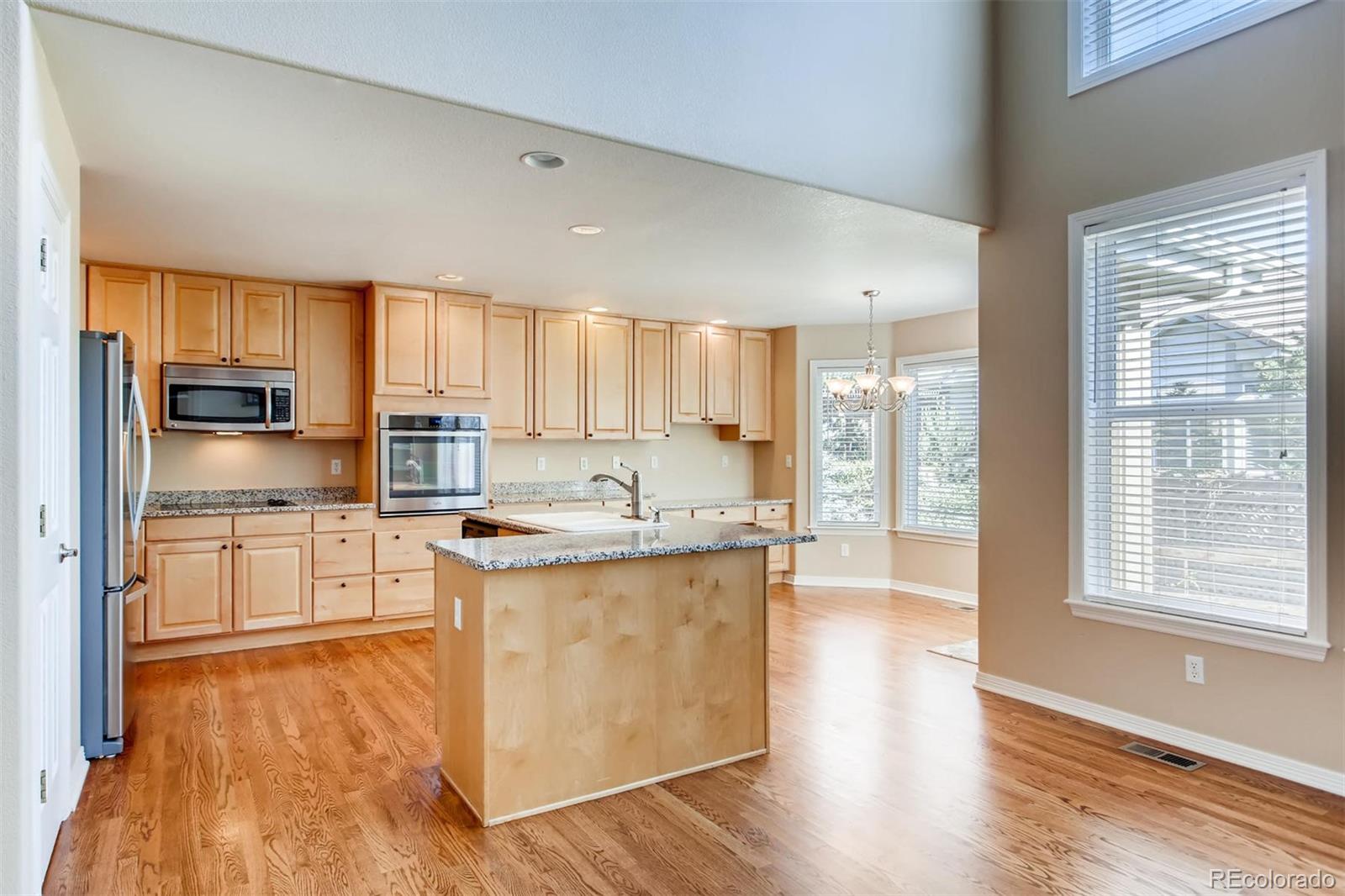 9535 East Aspen Hill Place Lone Tree, CO 80124 - Photo 10 of 28 a large kitchen with cabinets wooden floor and stainless steel appliances