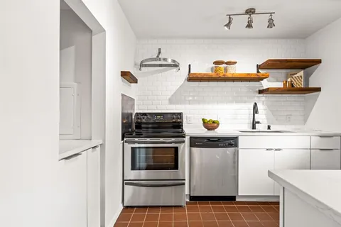 a kitchen with a stove and white cabinets