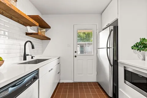 a kitchen with a refrigerator and a sink