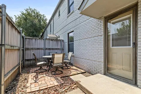 a view of a patio with table and chairs next to a yard