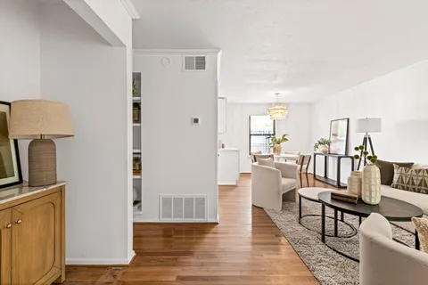 a view of a living room filled with furniture and a wooden floor