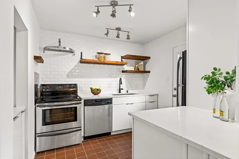 a kitchen with a stove and white cabinets