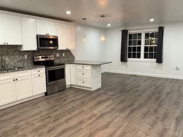 a kitchen with granite countertop a stove and a sink