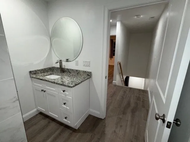 a bathroom with a granite countertop sink and a mirror