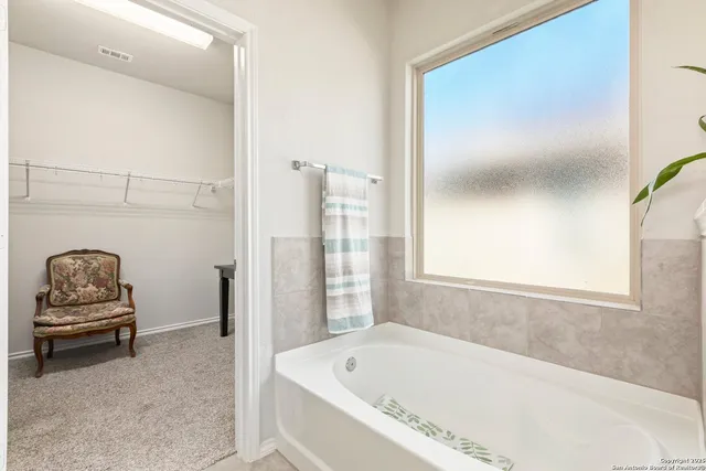 a bathroom with a tub and window