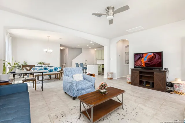 a living room with furniture a flat screen tv and kitchen view