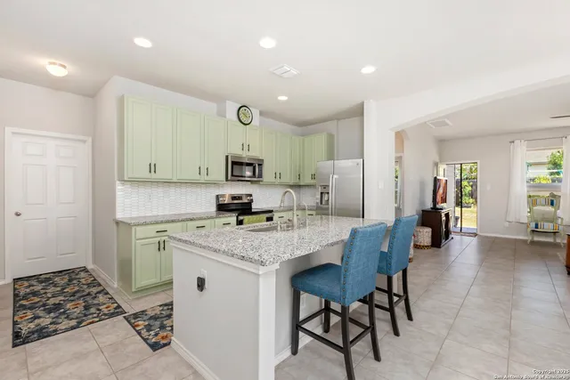 a kitchen with a sink and chairs