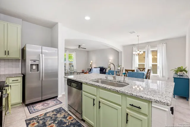a kitchen with granite countertop a sink stainless steel appliances and counter space