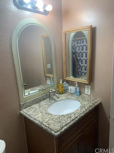 24510 Pace Drive Moreno Valley, CA 92557 - Photo 12 of 13 a bathroom with a granite countertop sink and a mirror