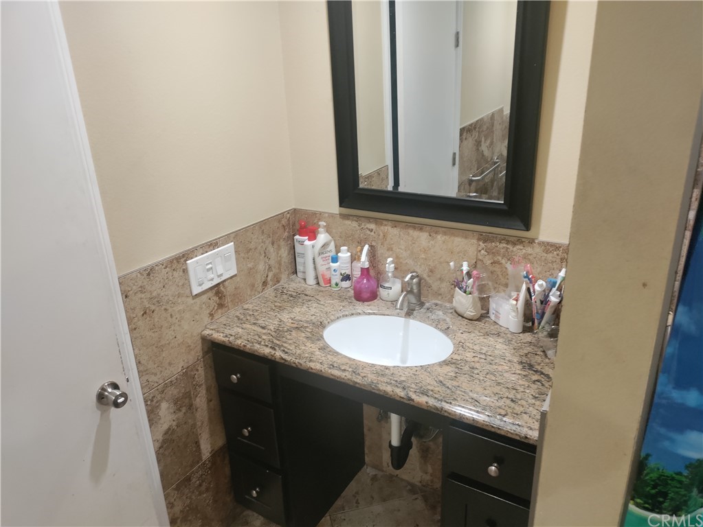 24510 Pace Drive Moreno Valley, CA 92557 - Photo 10 of 13 a bathroom with a granite countertop sink and a mirror