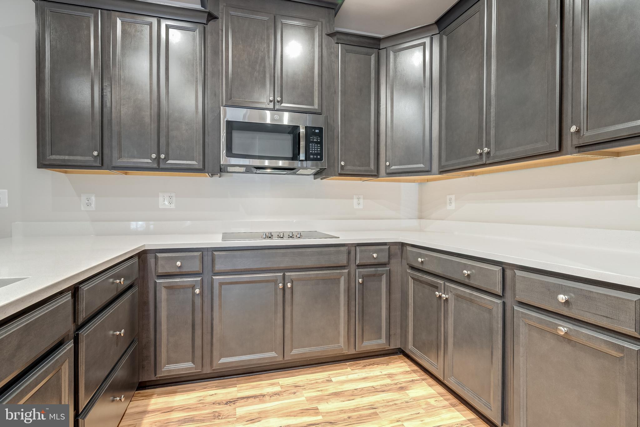 13504 Innovation Station Loop, Unit 2A Herndon, VA 20171 - Photo 18 of 36 a kitchen with stainless steel appliances granite countertop a sink and cabinets with wooden floor