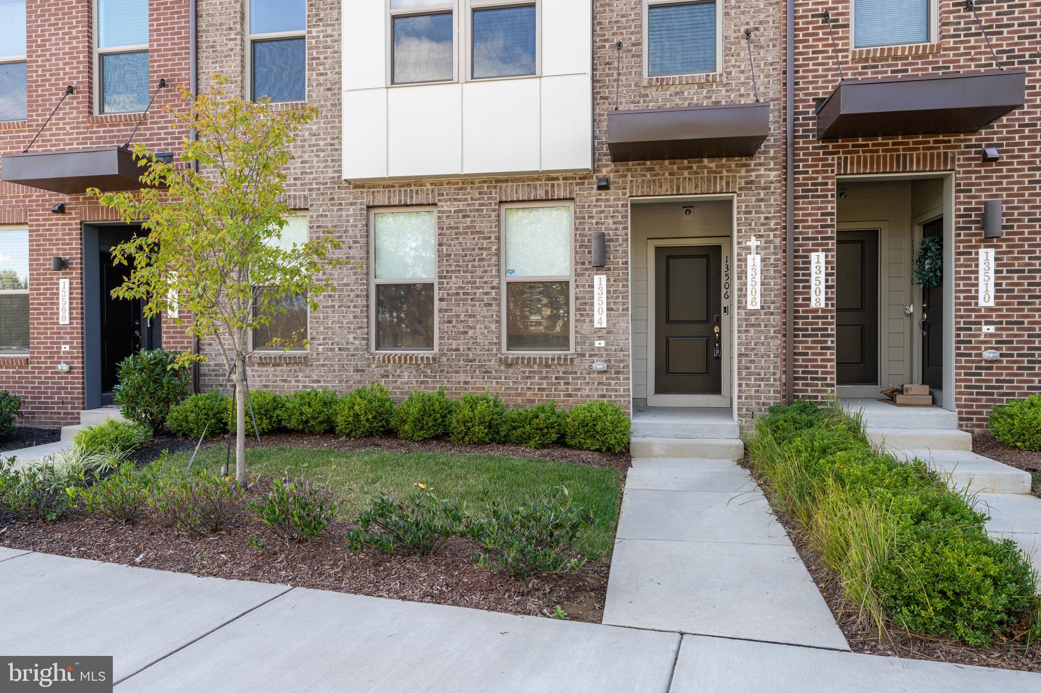 13504 Innovation Station Loop, Unit 2A Herndon, VA 20171 - Photo 2 of 36 a view of a brick house with a yard plants and large tree