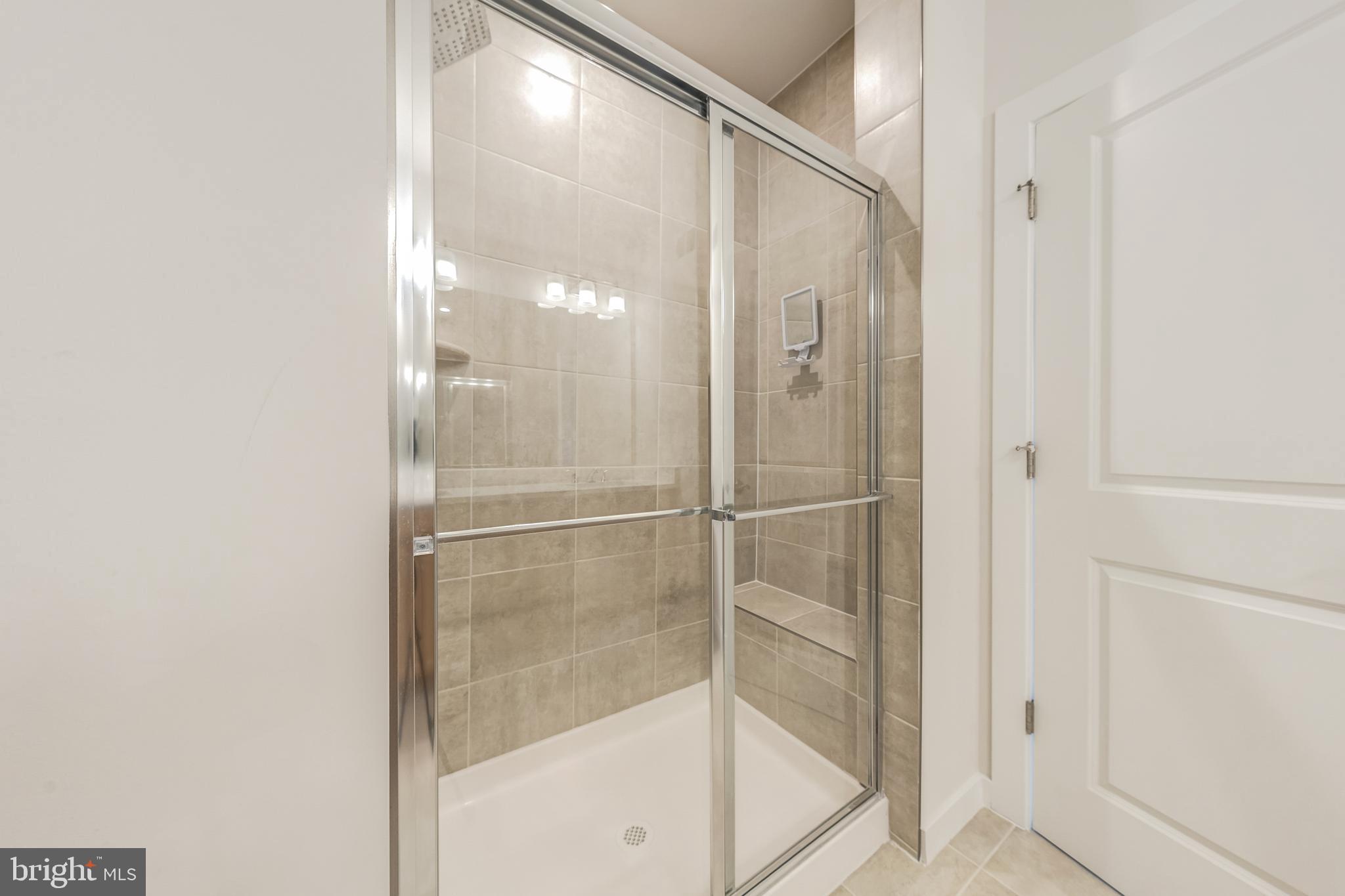 13504 Innovation Station Loop, Unit 2A Herndon, VA 20171 - Photo 27 of 36 a bathroom with a glass shower door