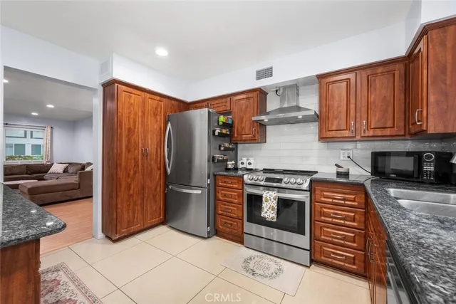 a kitchen with stainless steel appliances granite countertop a stove a sink and a microwave