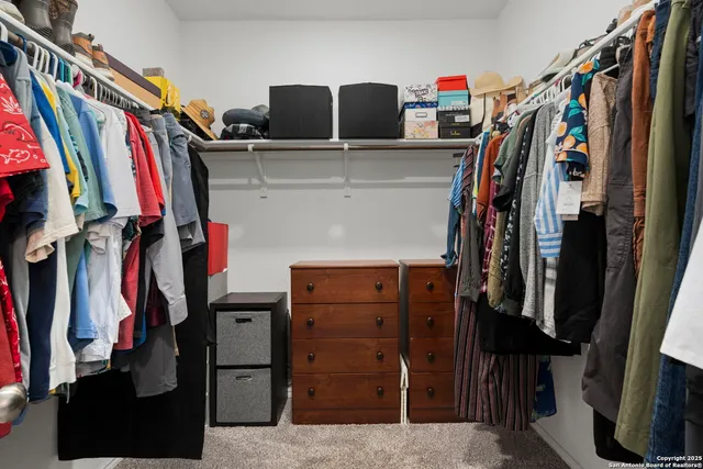 a view of walk in closet with clothes and shoes