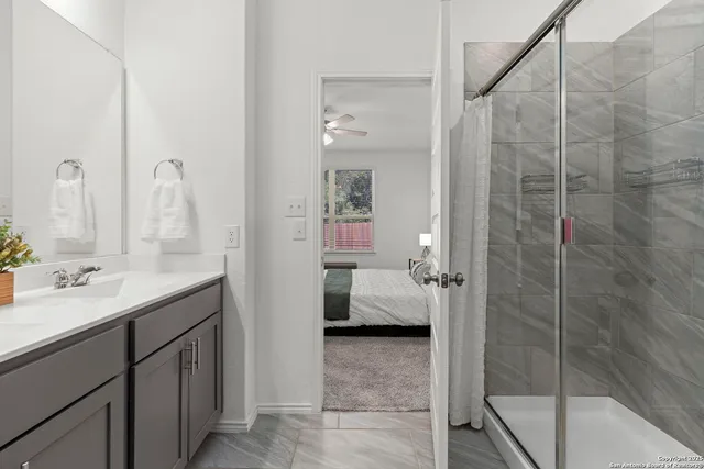 a en suite bathroom with a double vanity sink a mirror and a shower