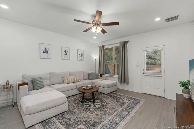 a living room with furniture and wooden floor