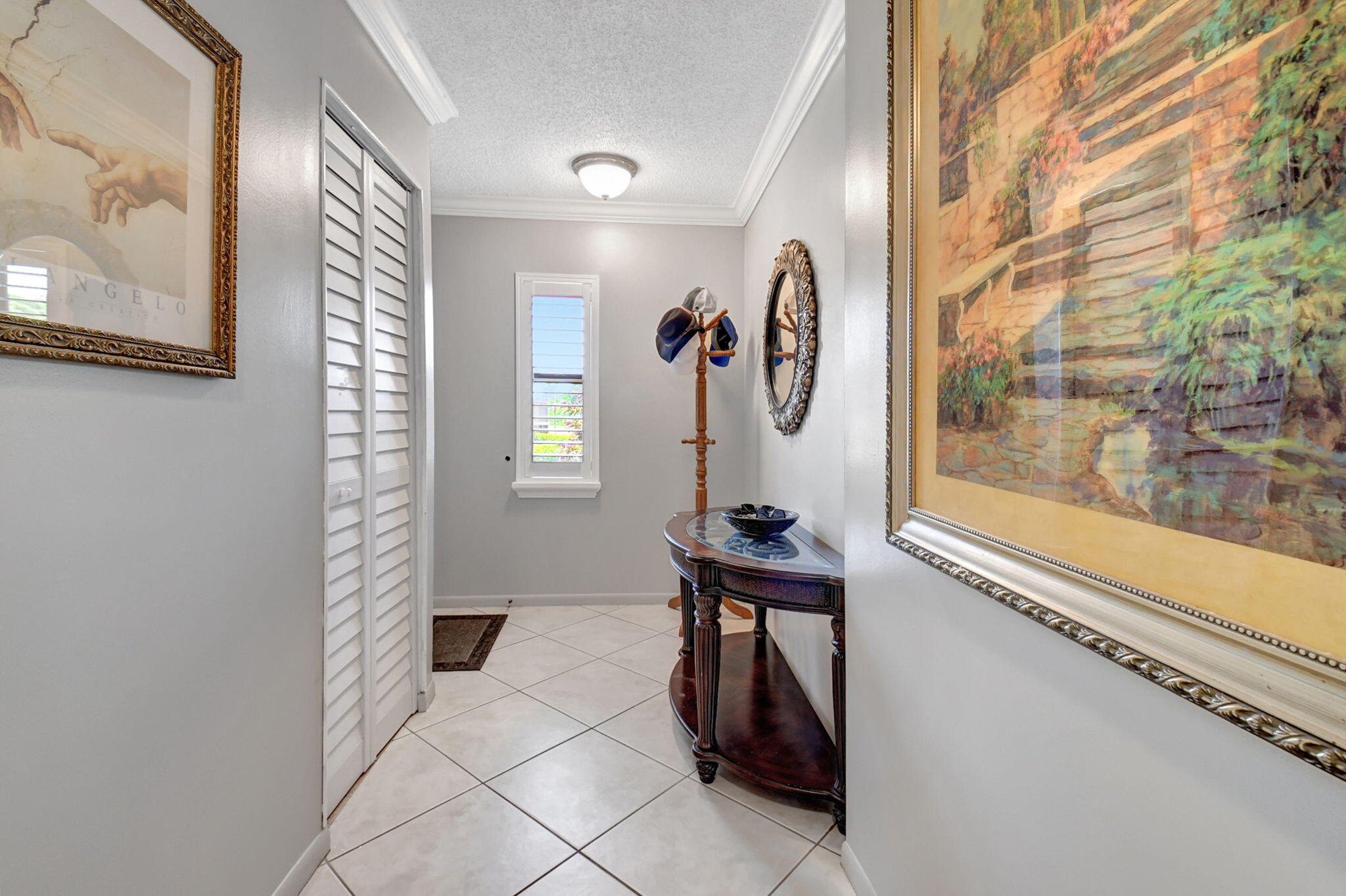 21214 Lago Circle, Unit B Boca Raton, FL 33433 - Photo 25 of 48 a view of a hallway with paintings on the wall and a window