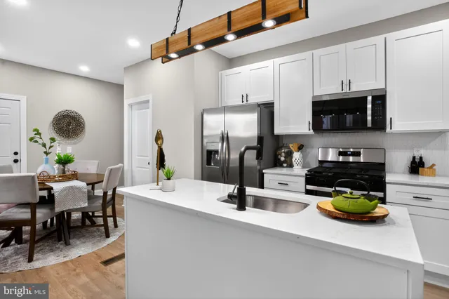 a kitchen with a sink a stove and chairs