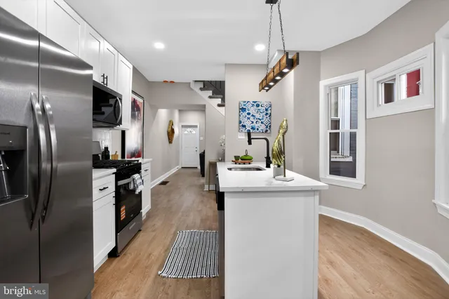 a kitchen with stainless steel appliances granite countertop a sink a stove and refrigerator