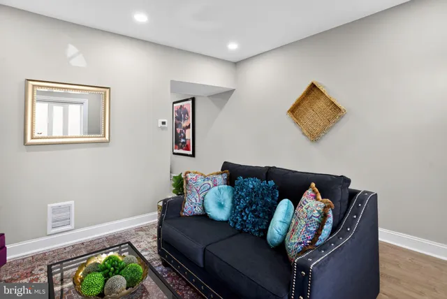 a living room with furniture and a wooden floor