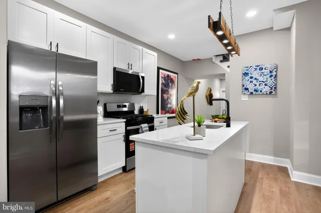 a kitchen with stainless steel appliances kitchen island a refrigerator and a stove top oven