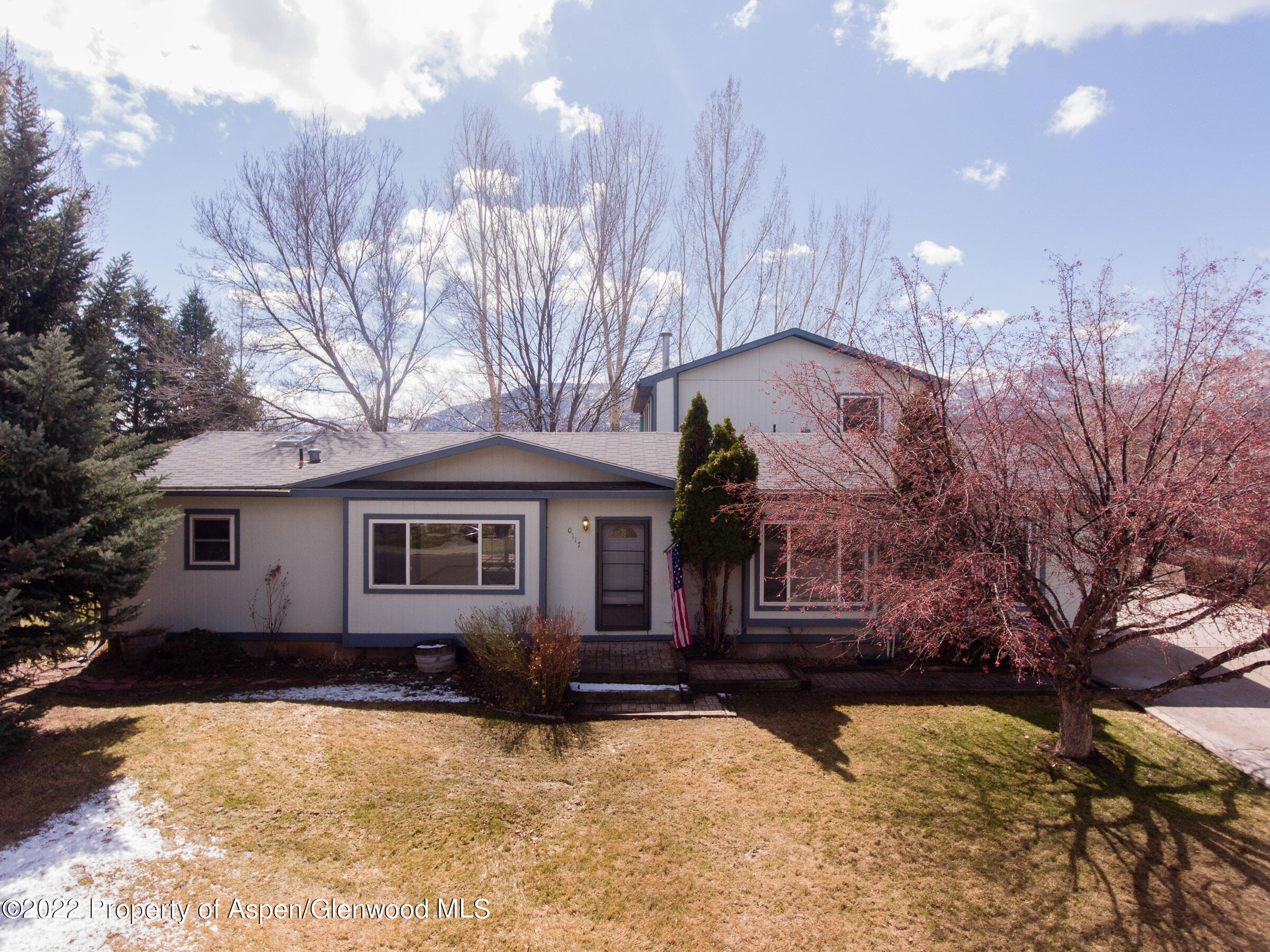 a front view of house with yard covered in snow