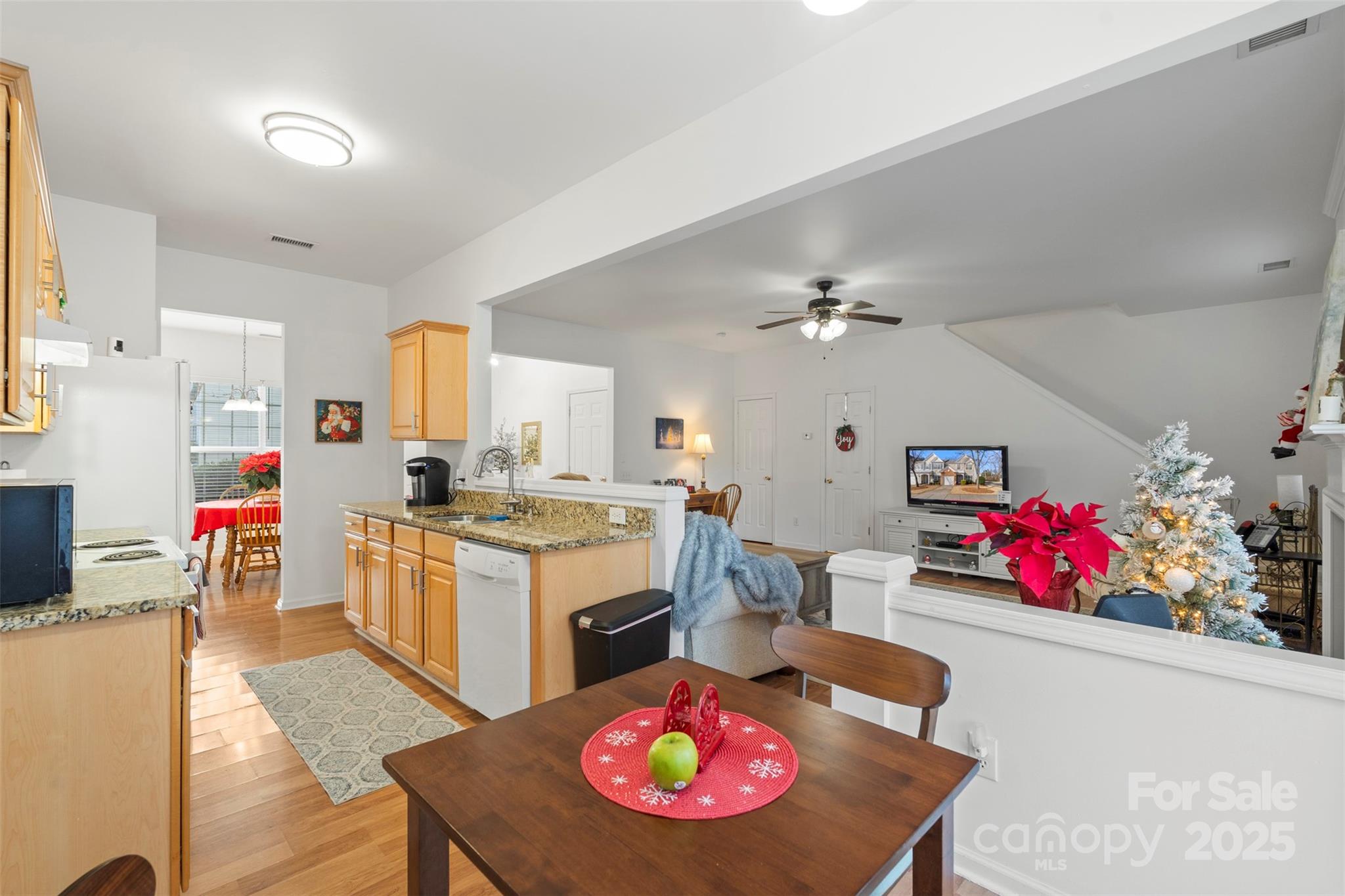 11730 Huxley Road Charlotte, NC 28277 - Photo 20 of 37 a kitchen with granite countertop a stove a sink dishwasher and white cabinets with wooden floor