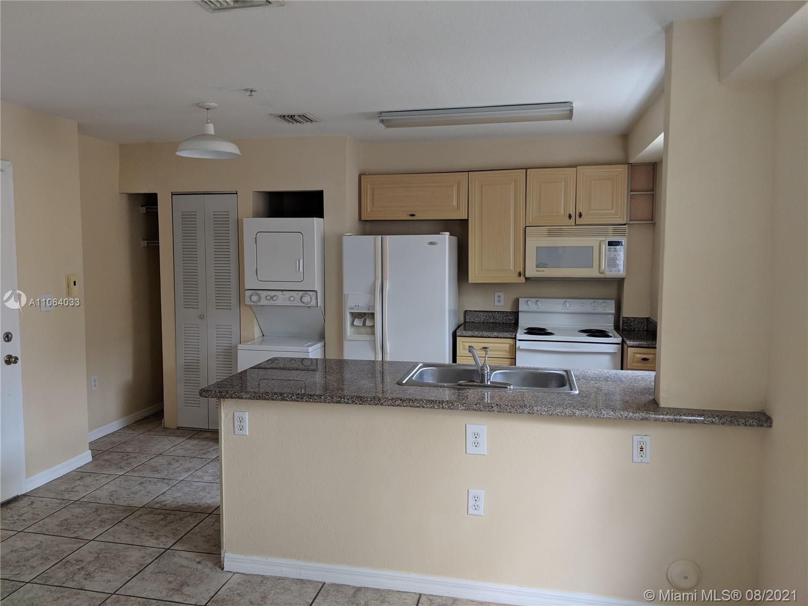 520 Southwest 5th Street, Unit 303 Miami, FL 33130 - Photo 3 of 49 a kitchen with kitchen island a counter top space a sink cabinets and stainless steel appliances